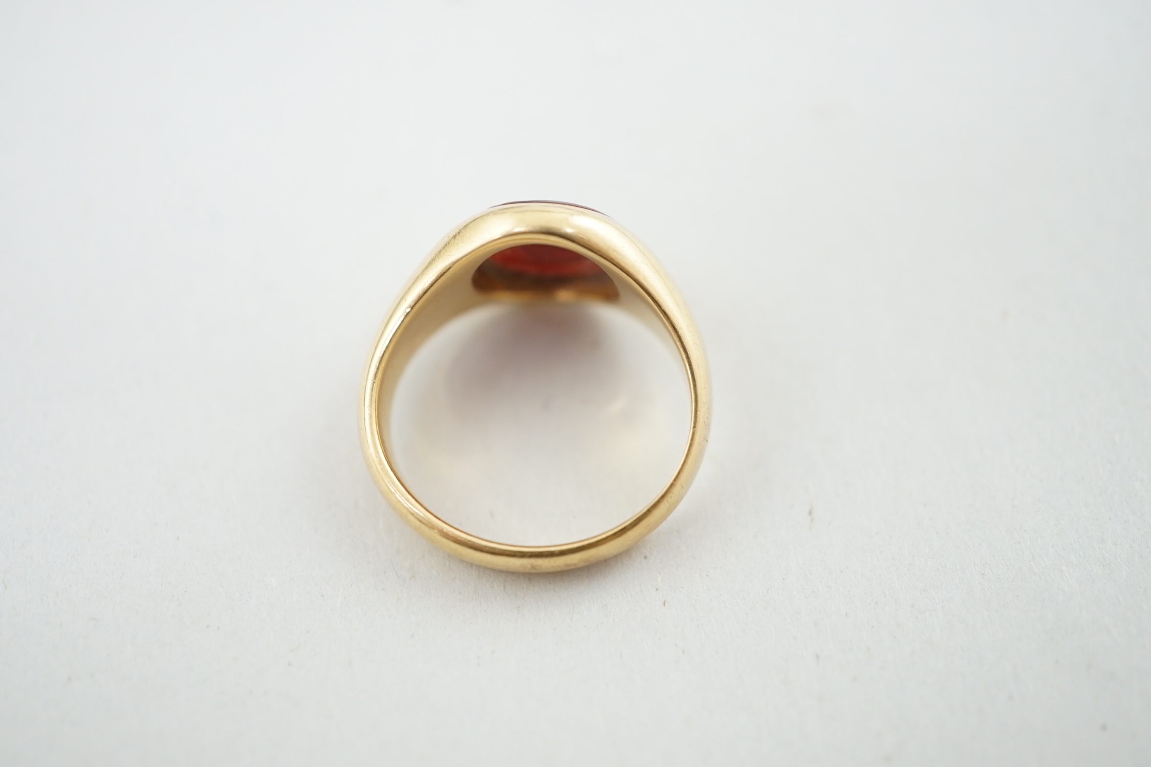 A George V 18ct gold and sardonyx set signet ring, the oval stone carved with family crest